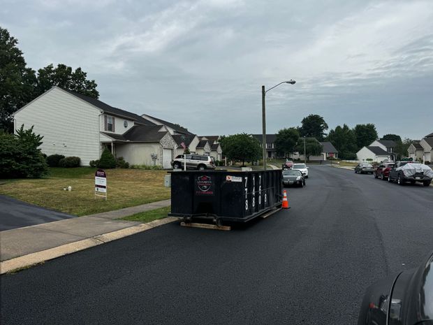 A dumpster is parked on the side of the road in a residential neighborhood. Dumpster Rental Lancaster