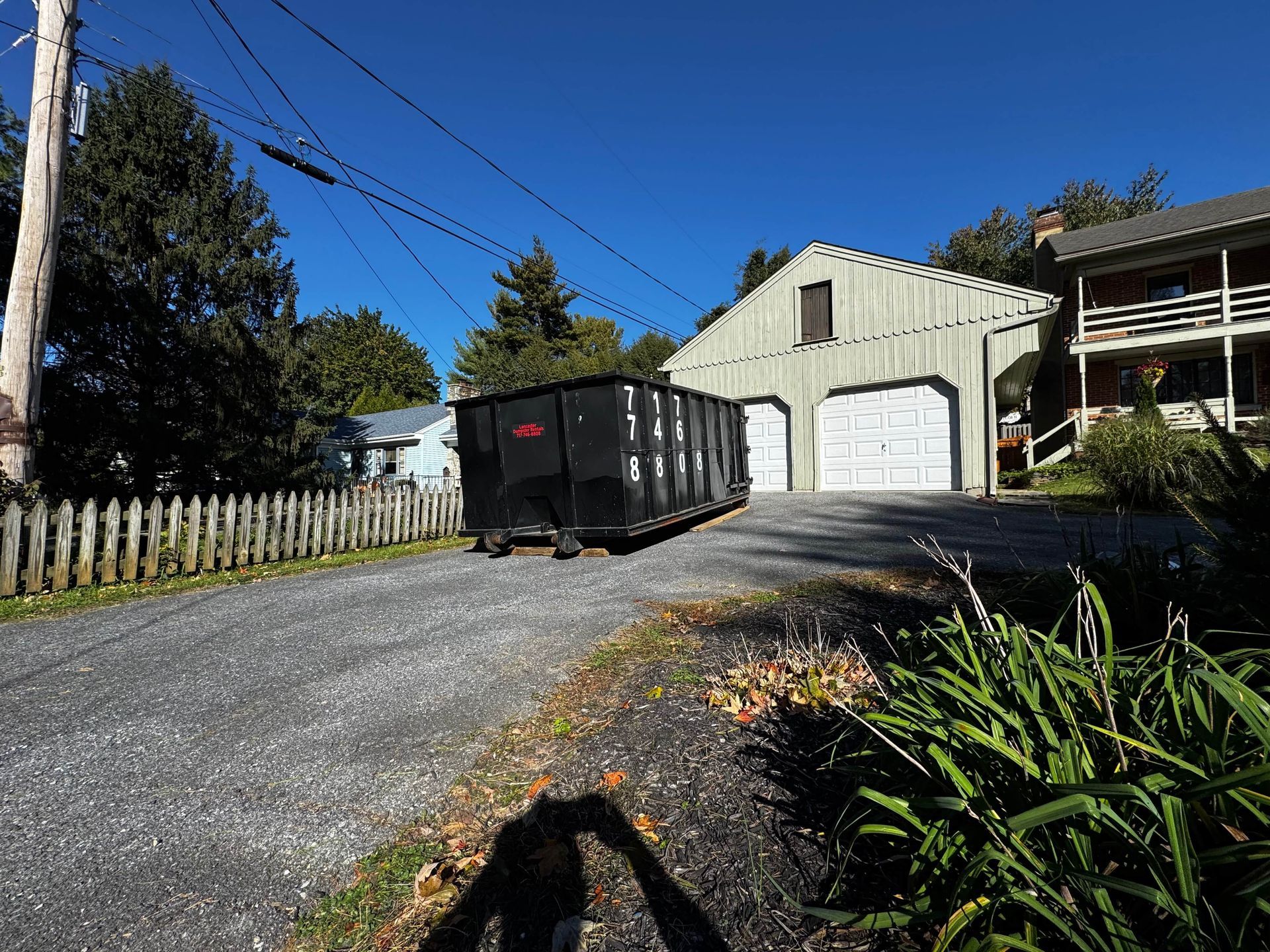 A dumpster is parked on the side of the road in front of a house. Dumpster Rentals Lancaster