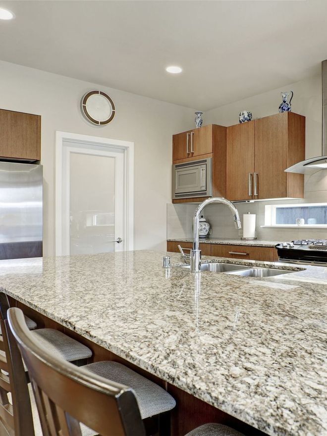 A kitchen with granite counter tops and stainless steel appliances