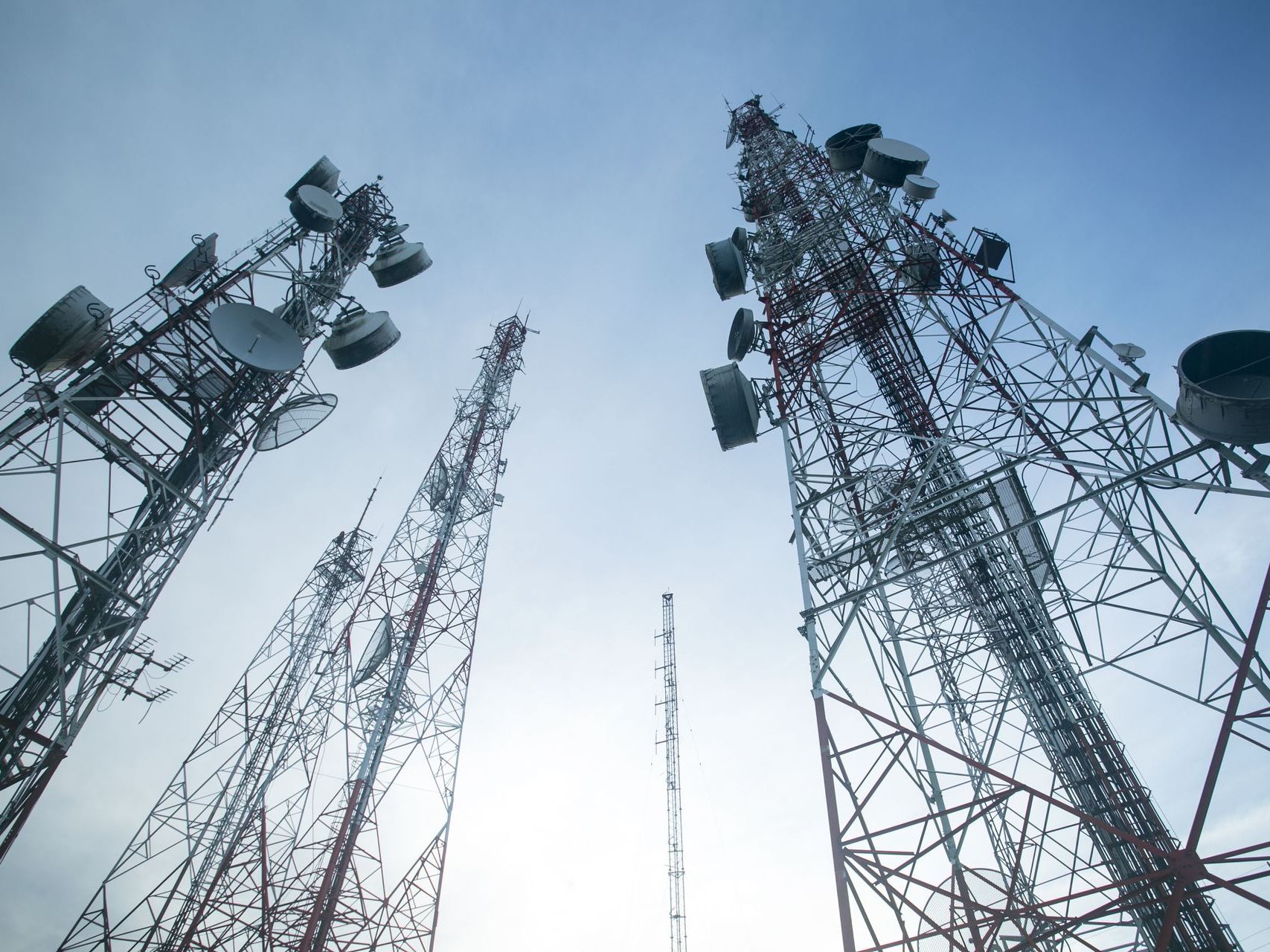 A photo of telephone towers against a blue sky.