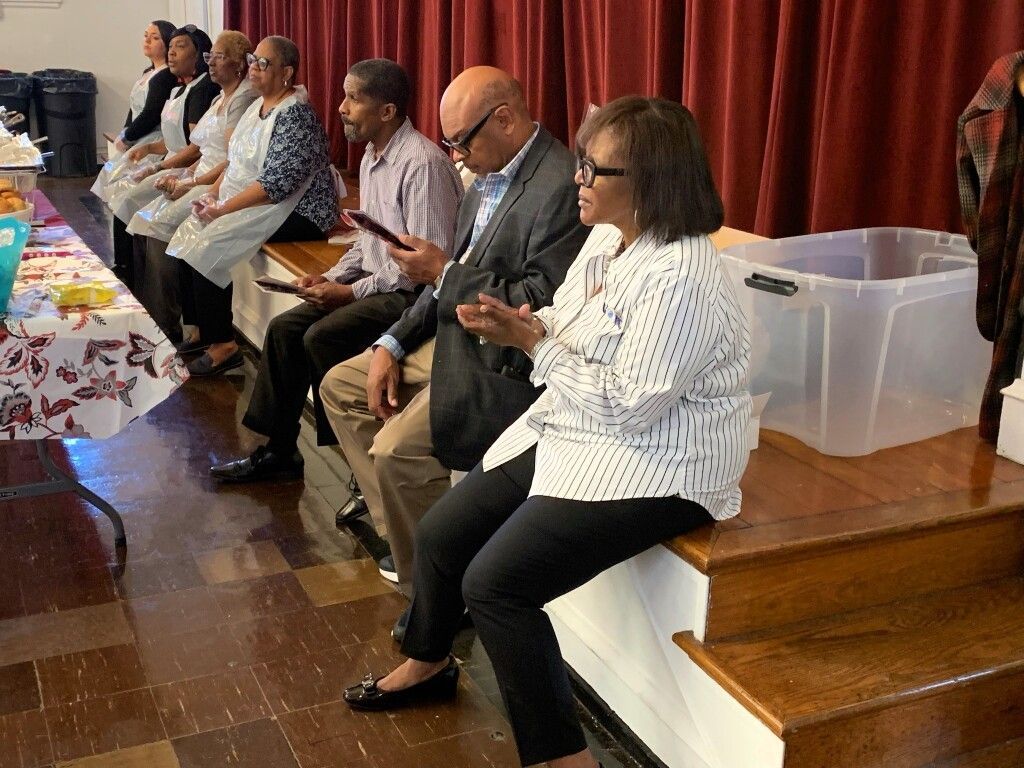 A group of people are sitting in a room looking at their phones.