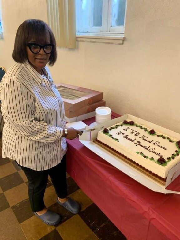 A woman is standing in front of a cake that says ' susan ' on it