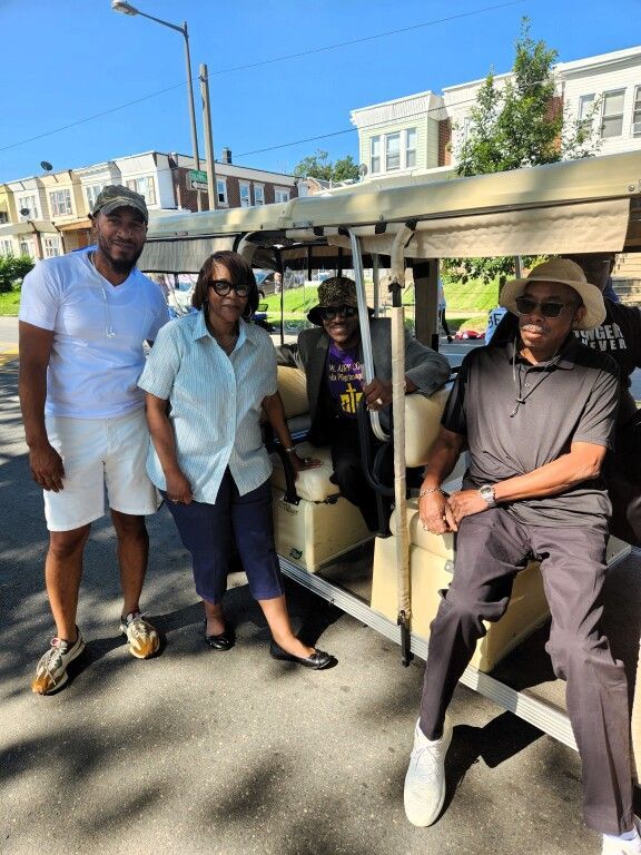 A group of people standing next to a golf cart
