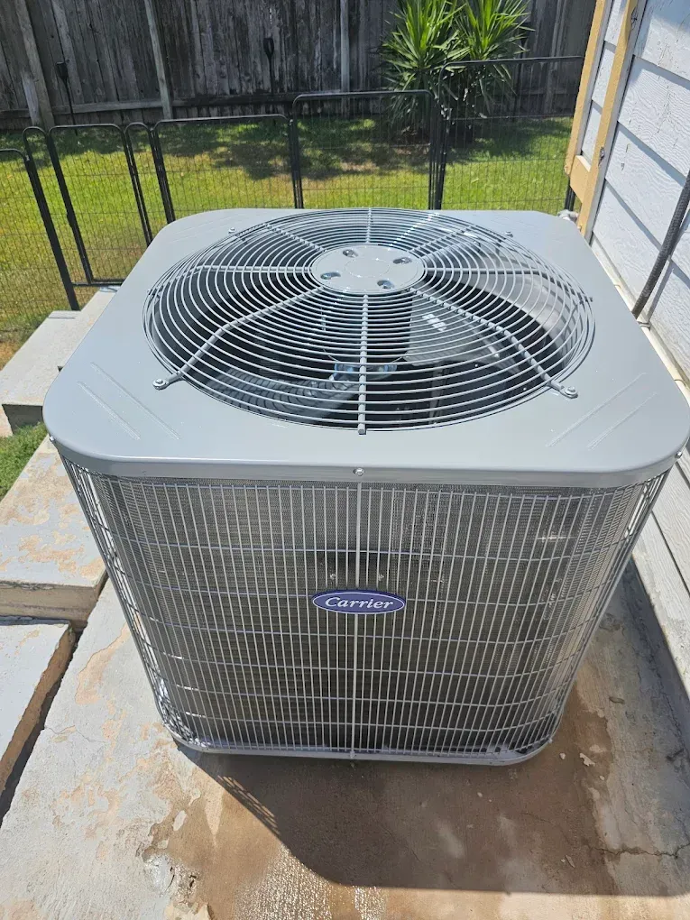 Gray Carrier air conditioning unit outside on concrete.