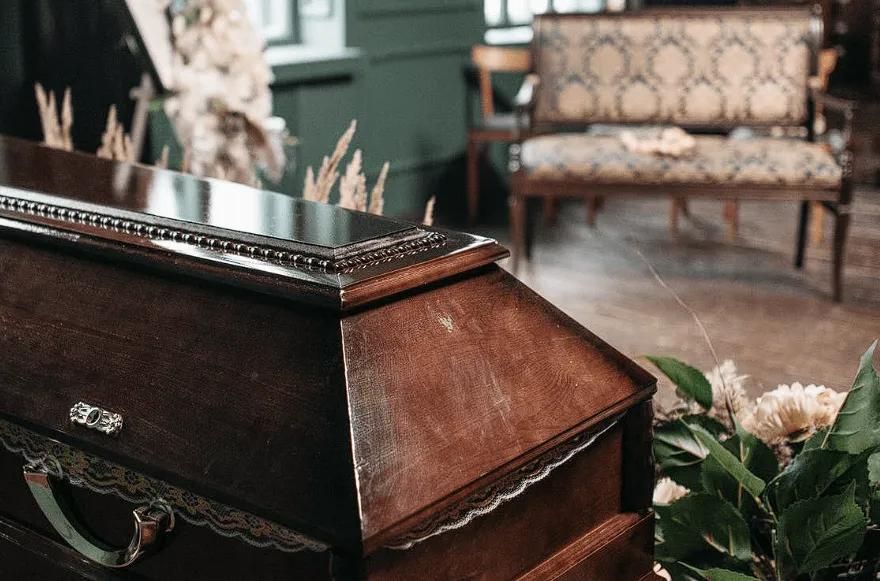 Wooden casket displayed during a memorial service at a funeral home and cremations in Plymouth Township, MI.