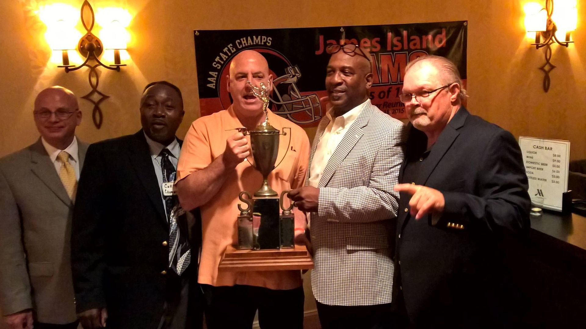 Group of men holding a trophy.