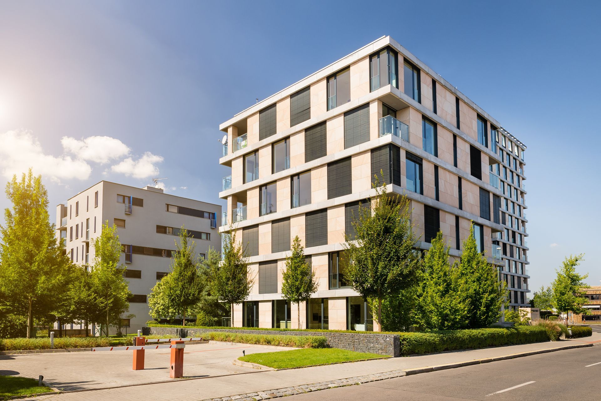 Modern multi-story apartment buildings with trees and a sunny sky. Modern multi-story apartment buildings with trees and a sunny sky.