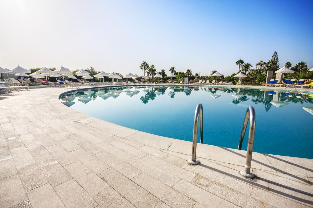 A Large Swimming Pool With Stairs Leading To It In A Resort— Holiday Coast Pools & Water In Coffs Harbour, NSW