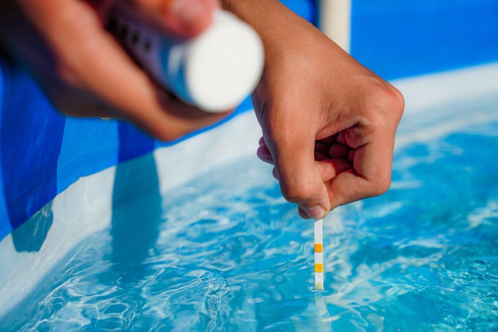 Hands Testing Swimming Pool Water