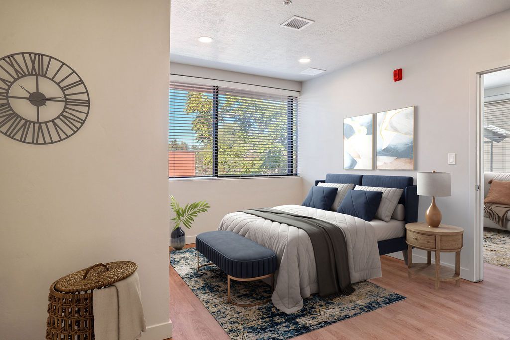 A bedroom with a large bed and a clock on the wall.