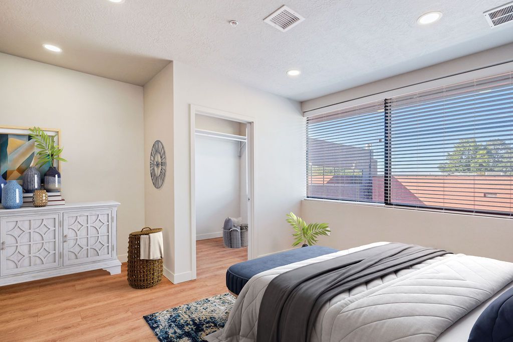 A bedroom with a large bed and a large window.