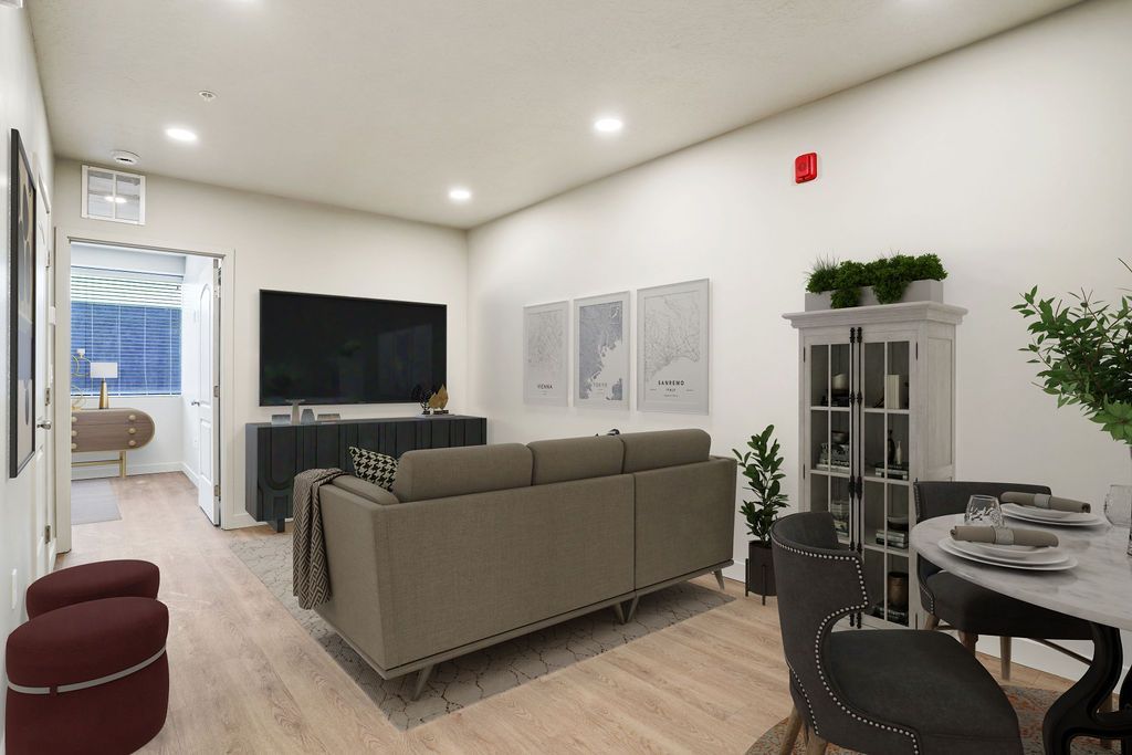 A living room with a couch , chairs , a table and a television.