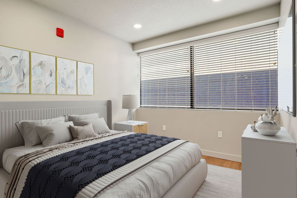 A bedroom with a large bed and a large window.