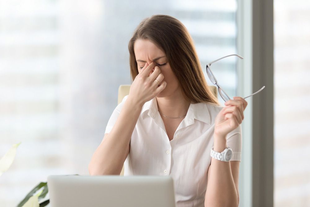 Woman With Glasses, Eyes Closed, Hand on Nose — Living Well Chiropractic Coffs Harbour in Coffs Harbour, NSW