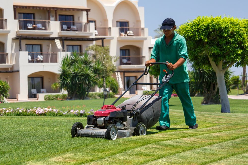 Professional lawn care worker mowing grass at a commercial site.