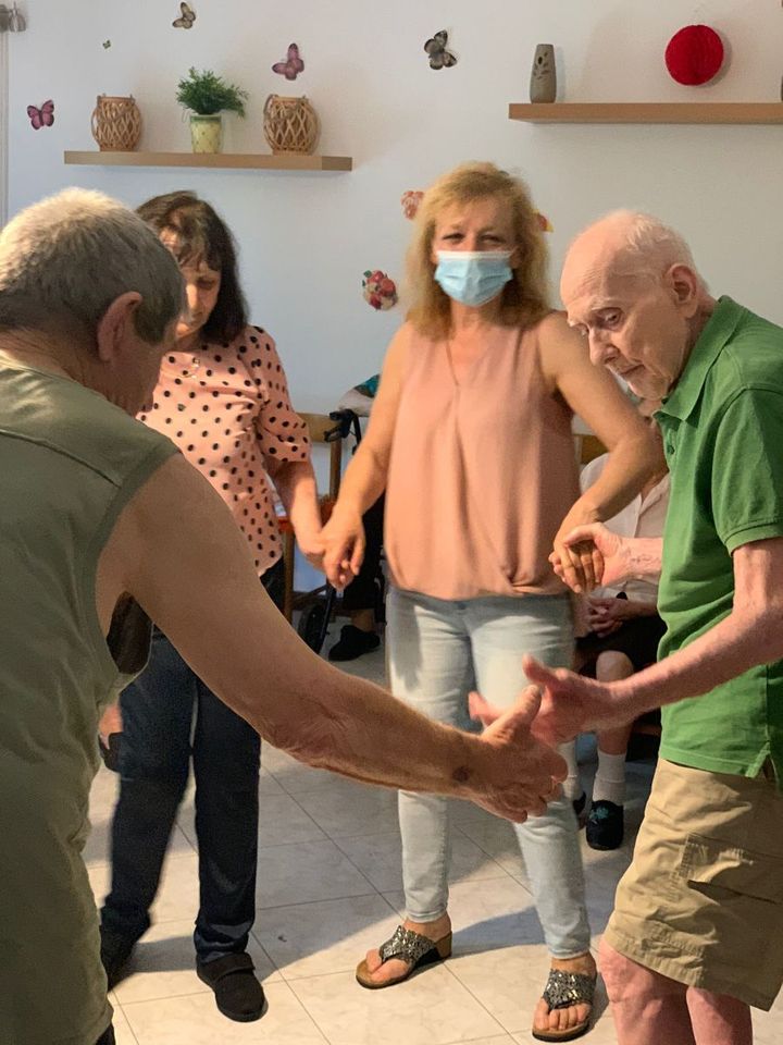 anziani ballano in cerchio
