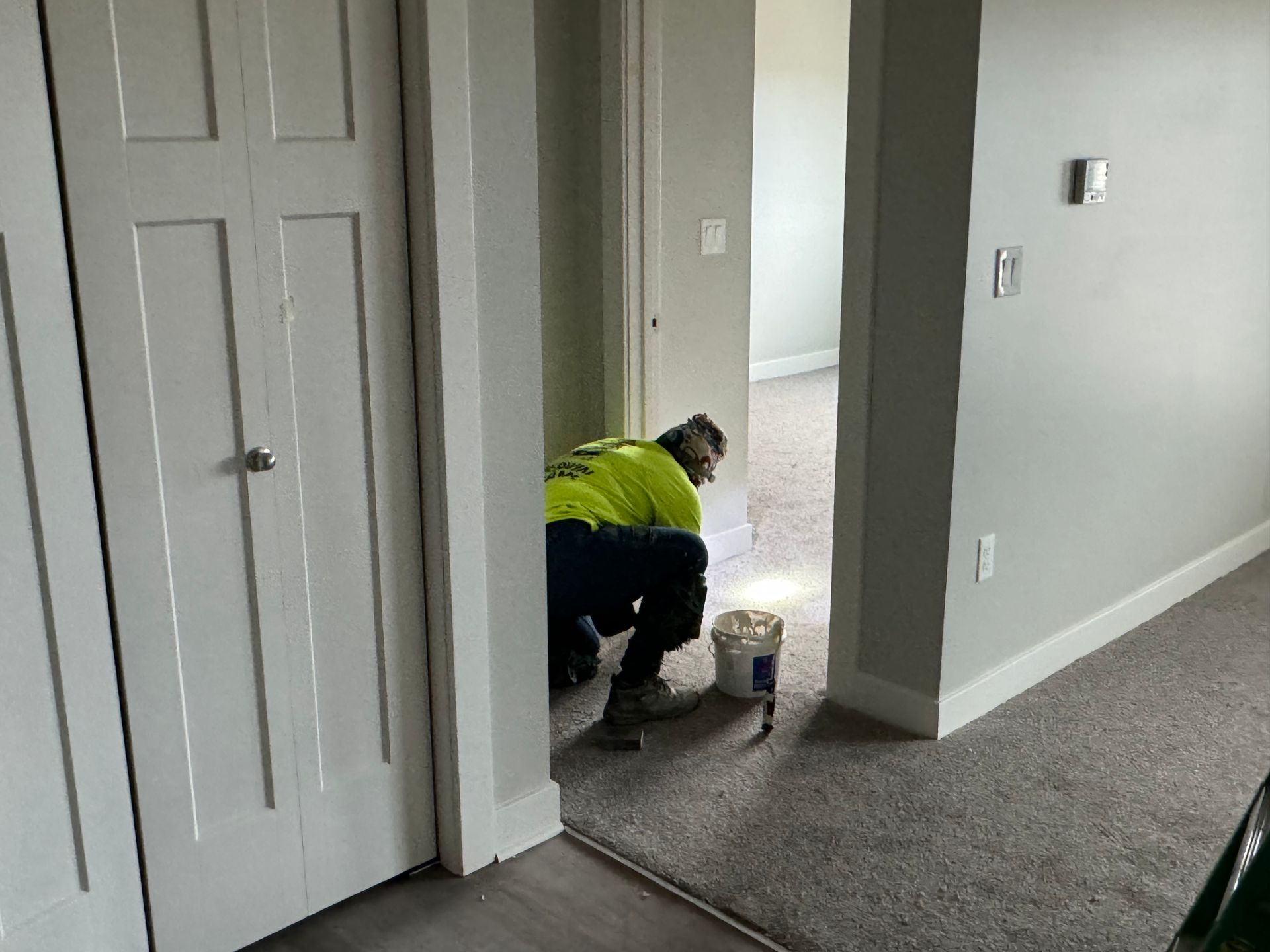 a man is kneeling on the floor in a hallway .