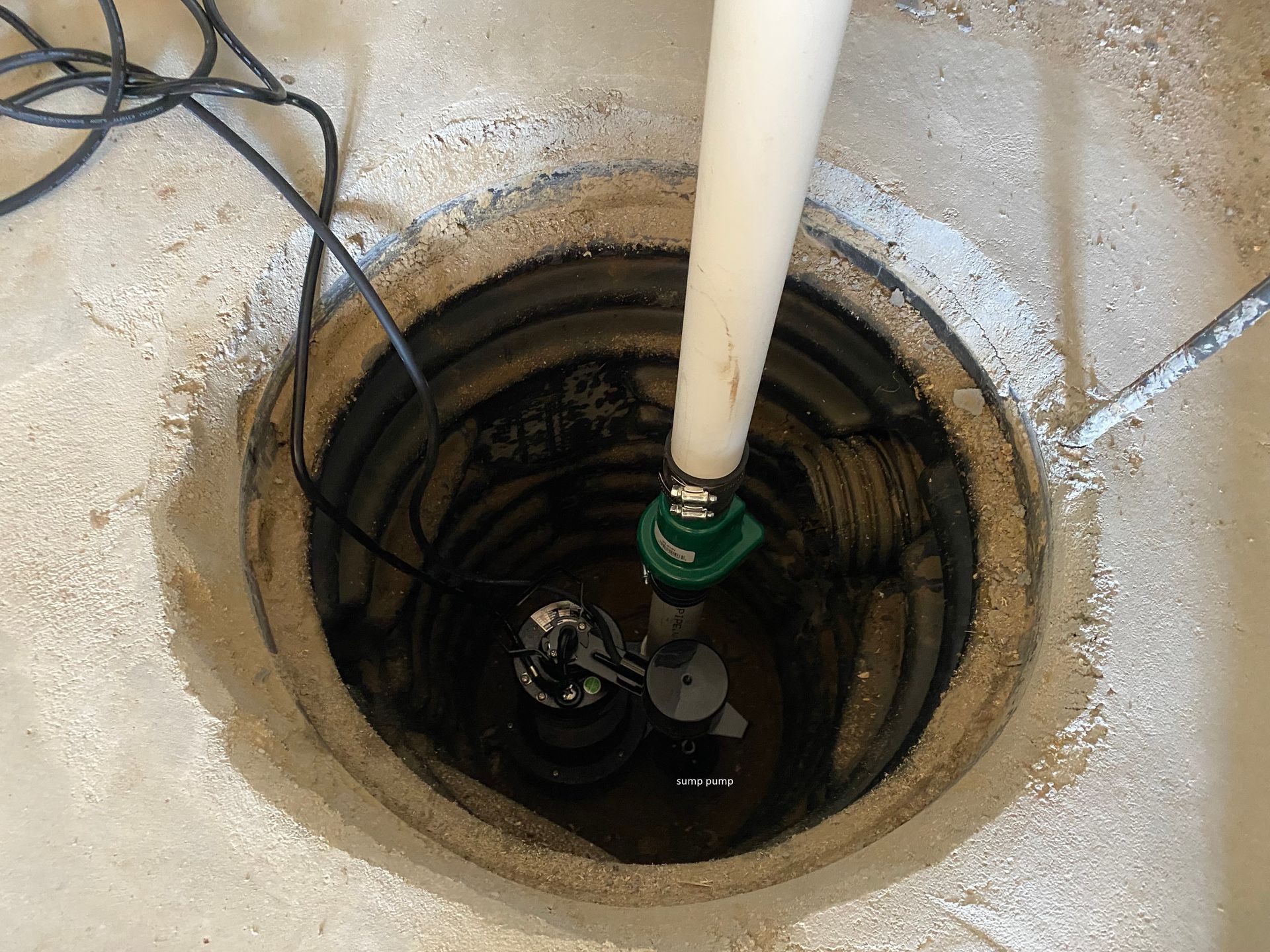 a sump pump is sitting in a hole in the floor .