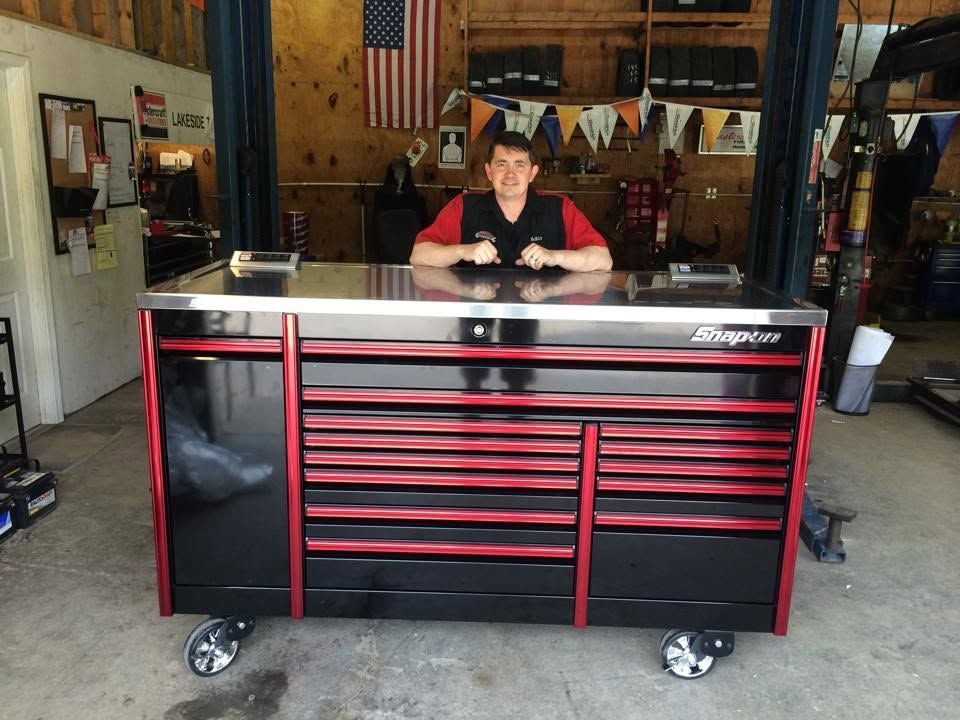 Man leaning on a red-and-black tool chest in a garage workshop | Lakeside Automotive