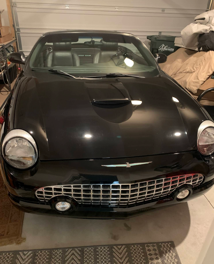 Black vintage sports car parked in a garage, front view. | Lakeside Automotive