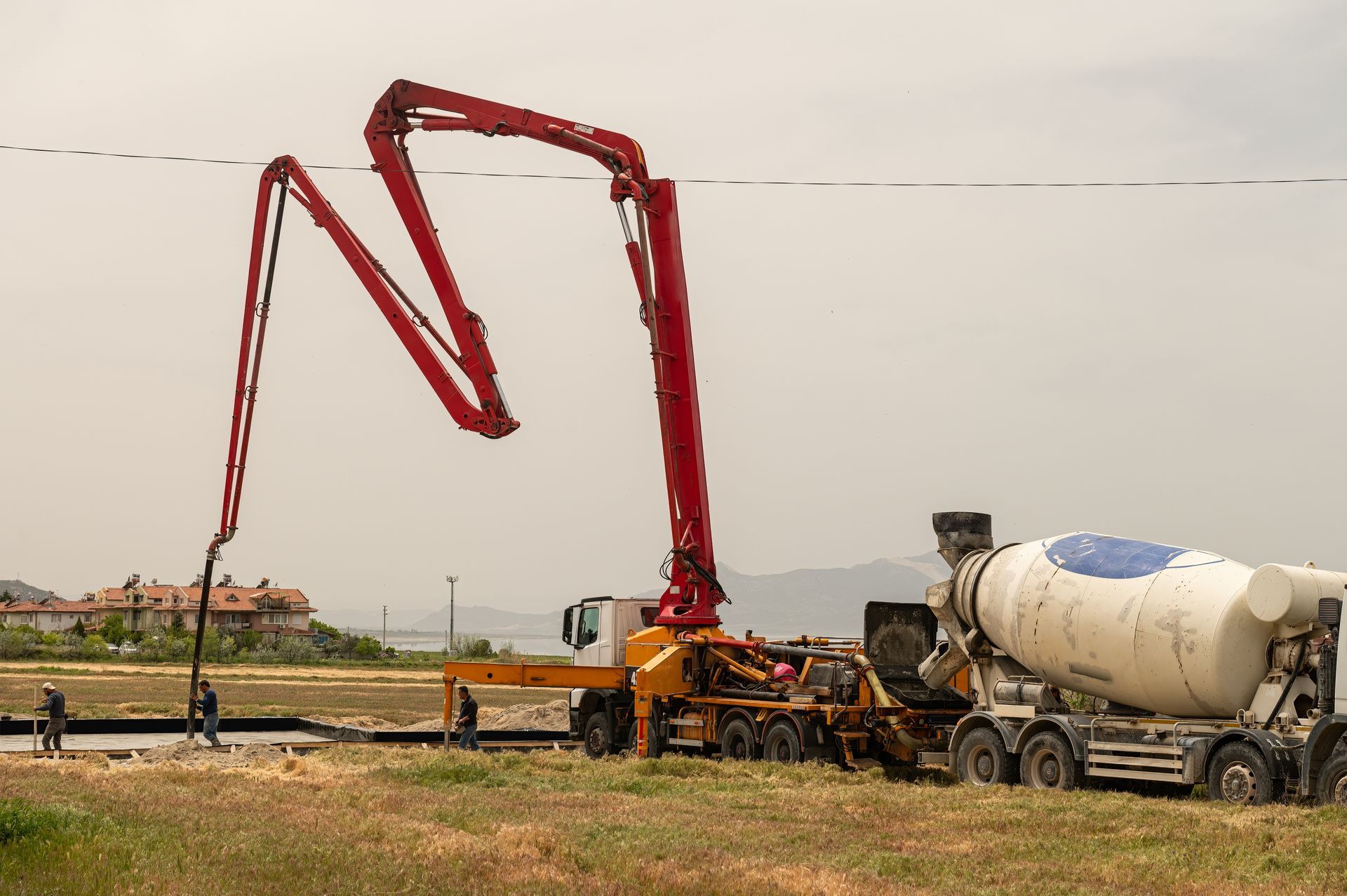 A Concrete Pump Is Being Used To Pump Concrete Into A Concrete Mixer Truck — Doug's Concrete Pumping Pty Ltd in Glenella, QLD