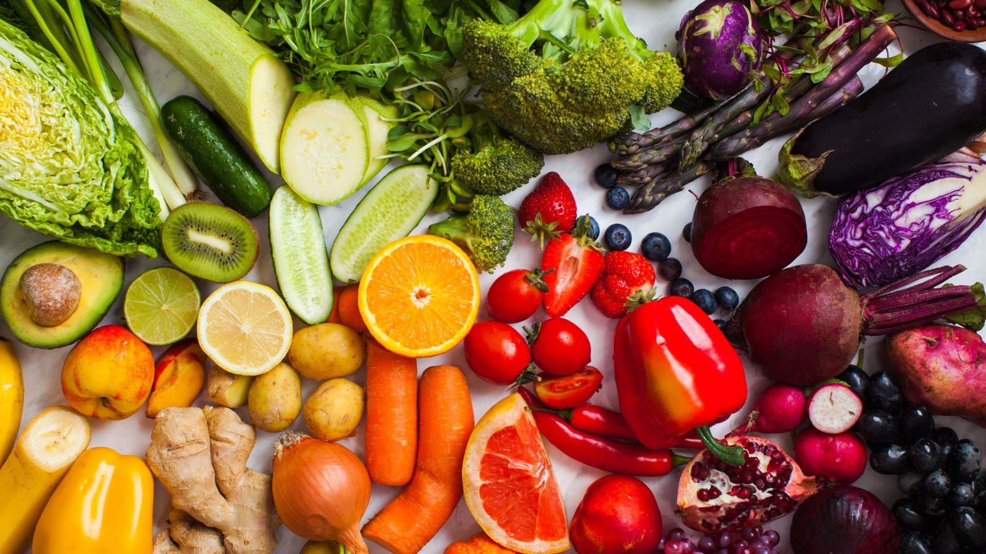 There are many different types of fruits and vegetables on the table.