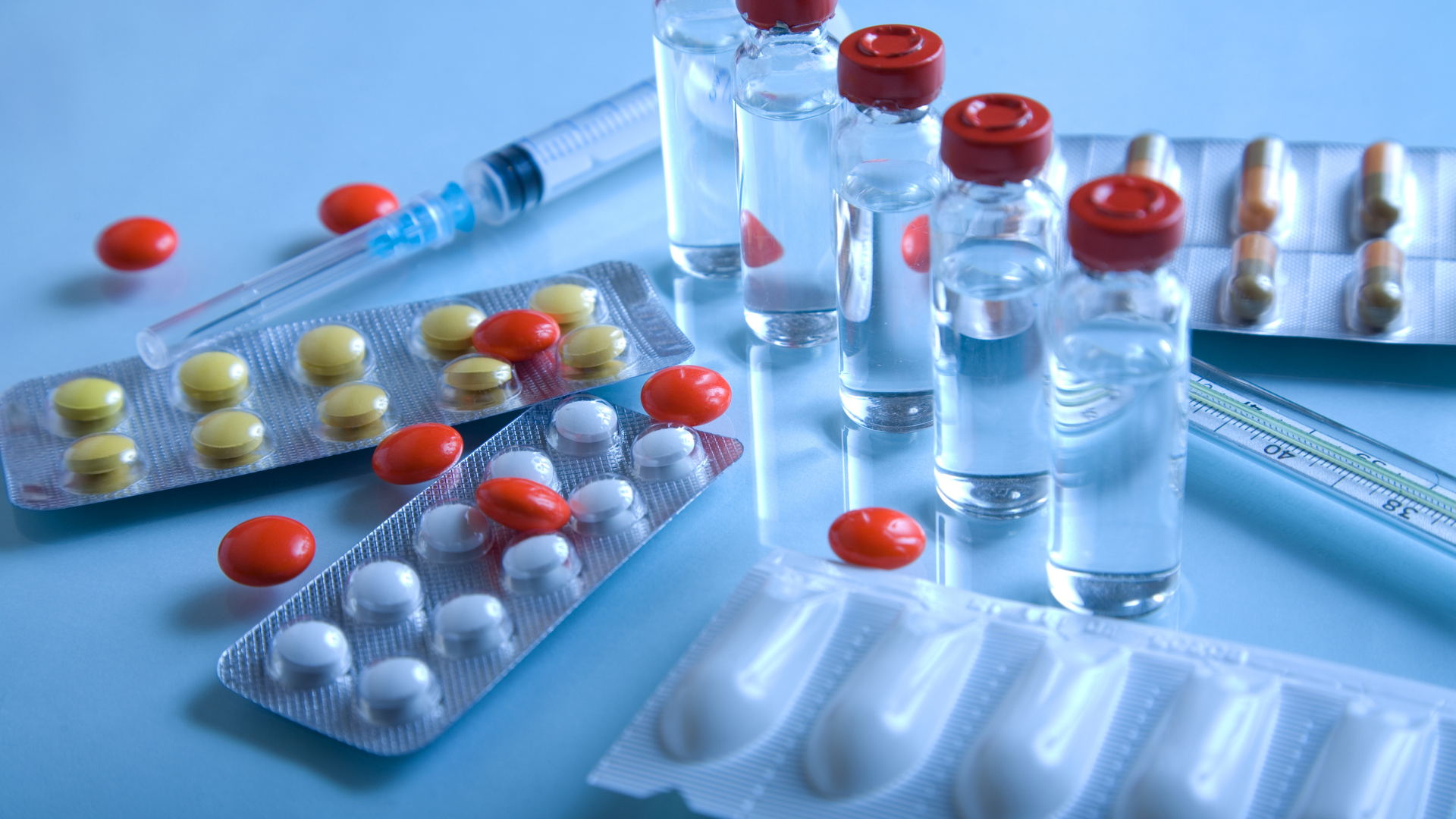 There are many different types of pills and bottles on the table.