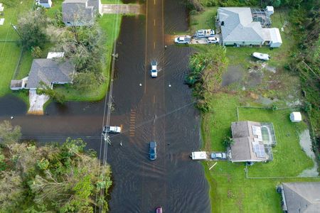 Aerial view of a flooded neighborhood with submerged streets and homes surrounded by water