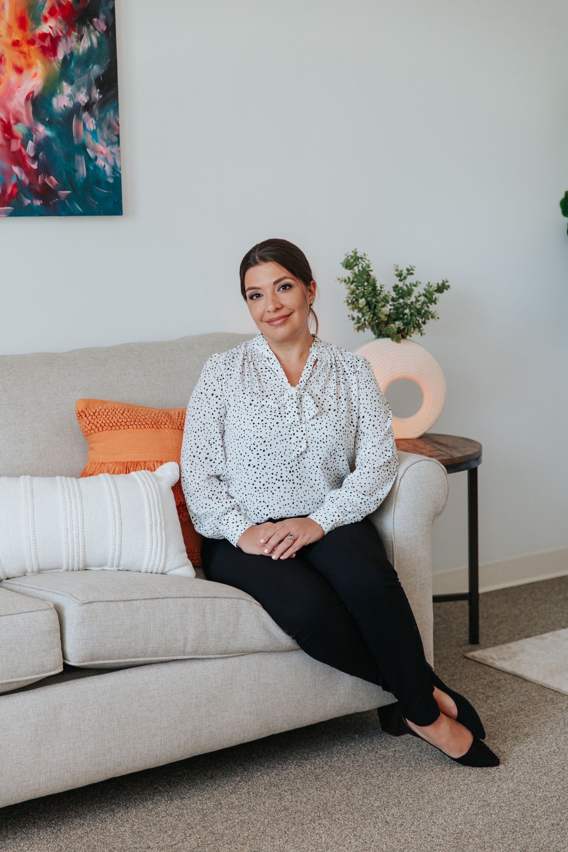 A woman is sitting on a couch in a living room.
