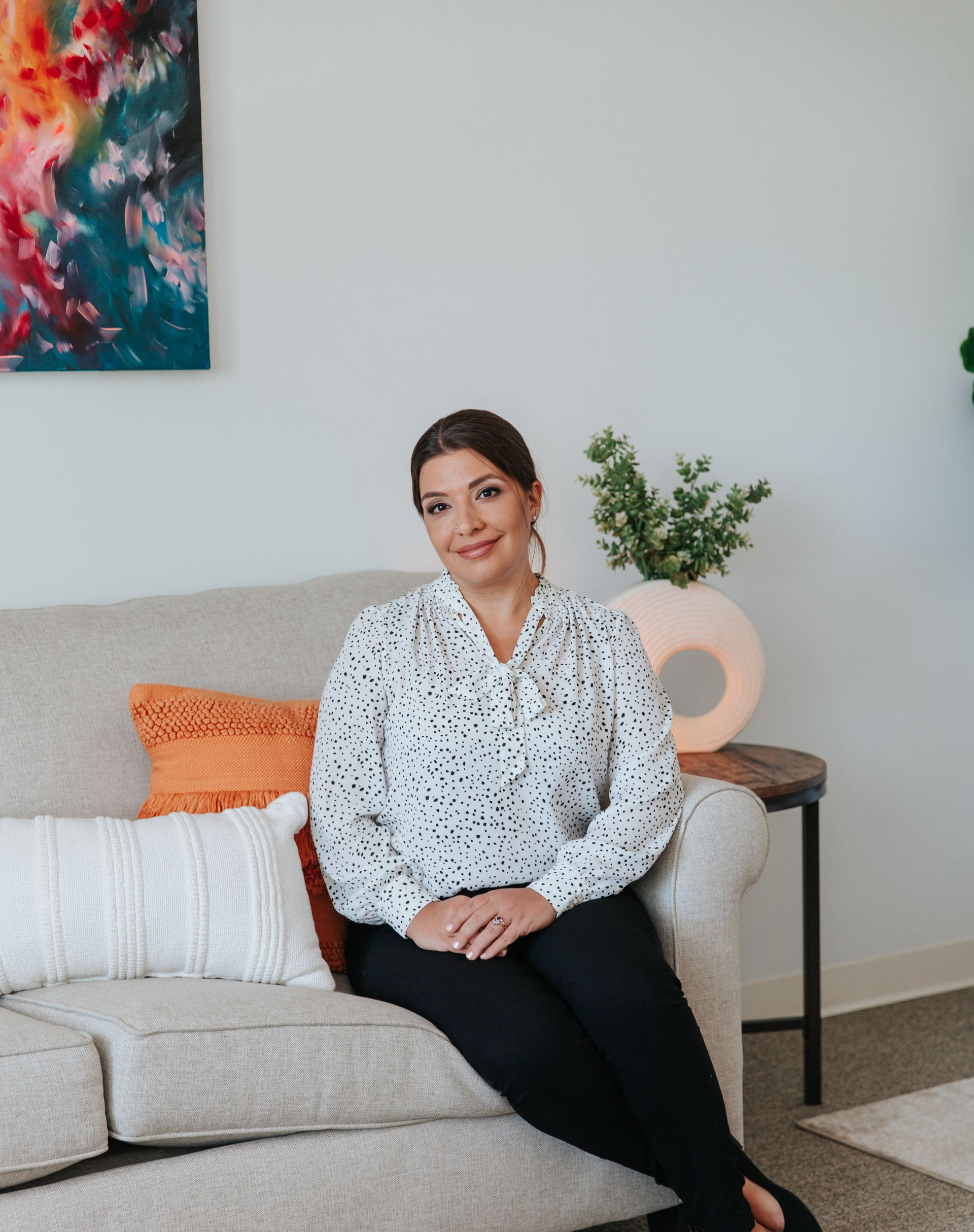 A woman is sitting on a couch in a living room.