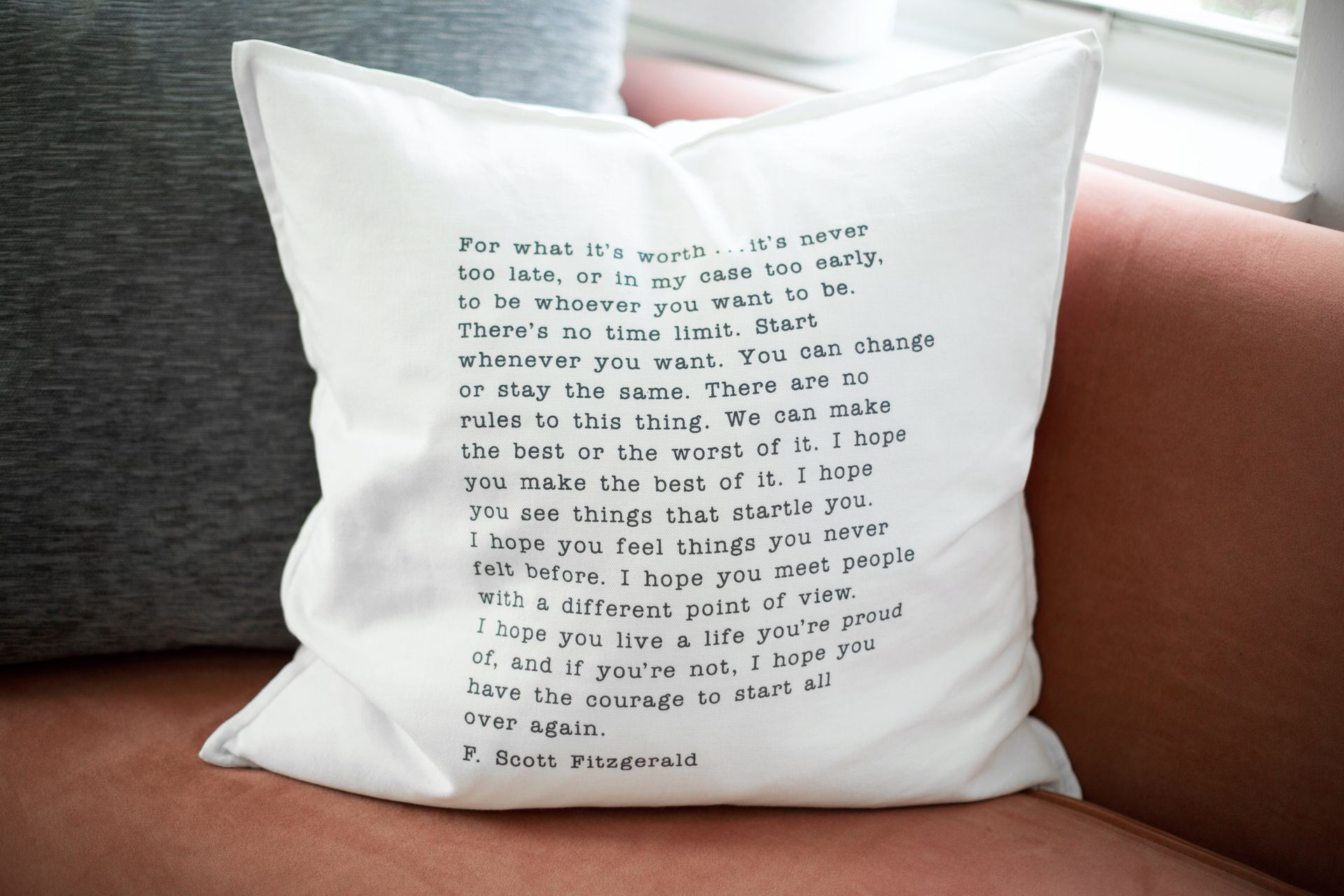 A white pillow with a poem on it is sitting on a couch