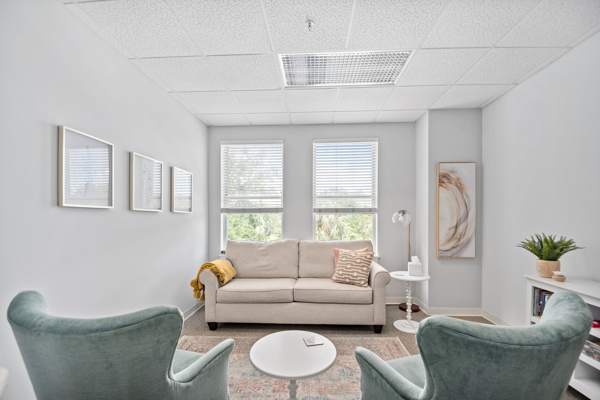 A living room with a couch , chairs , and a table.