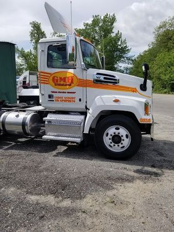 A white semi truck is parked in a parking lot.