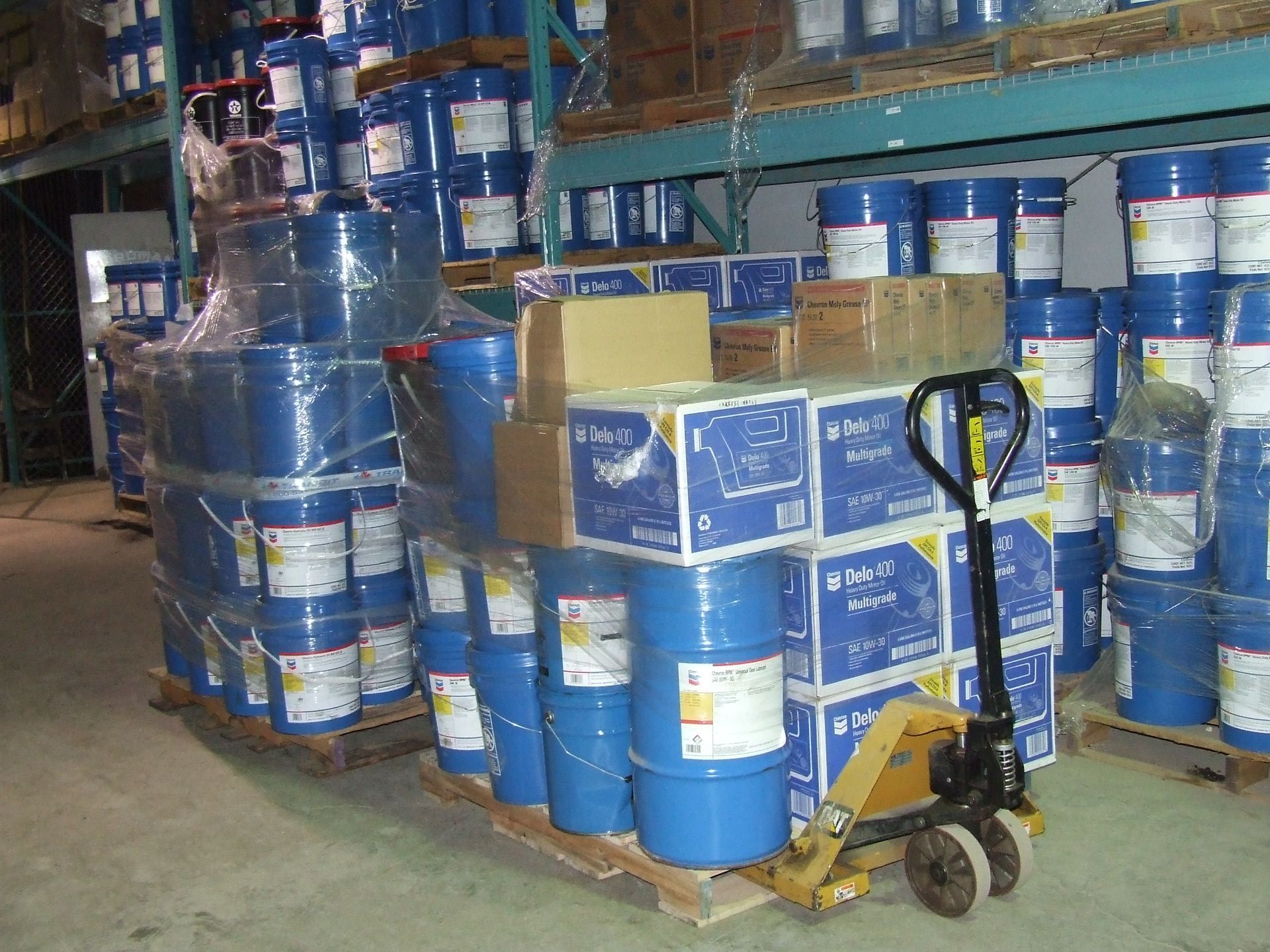 A warehouse filled with lots of blue barrels and boxes