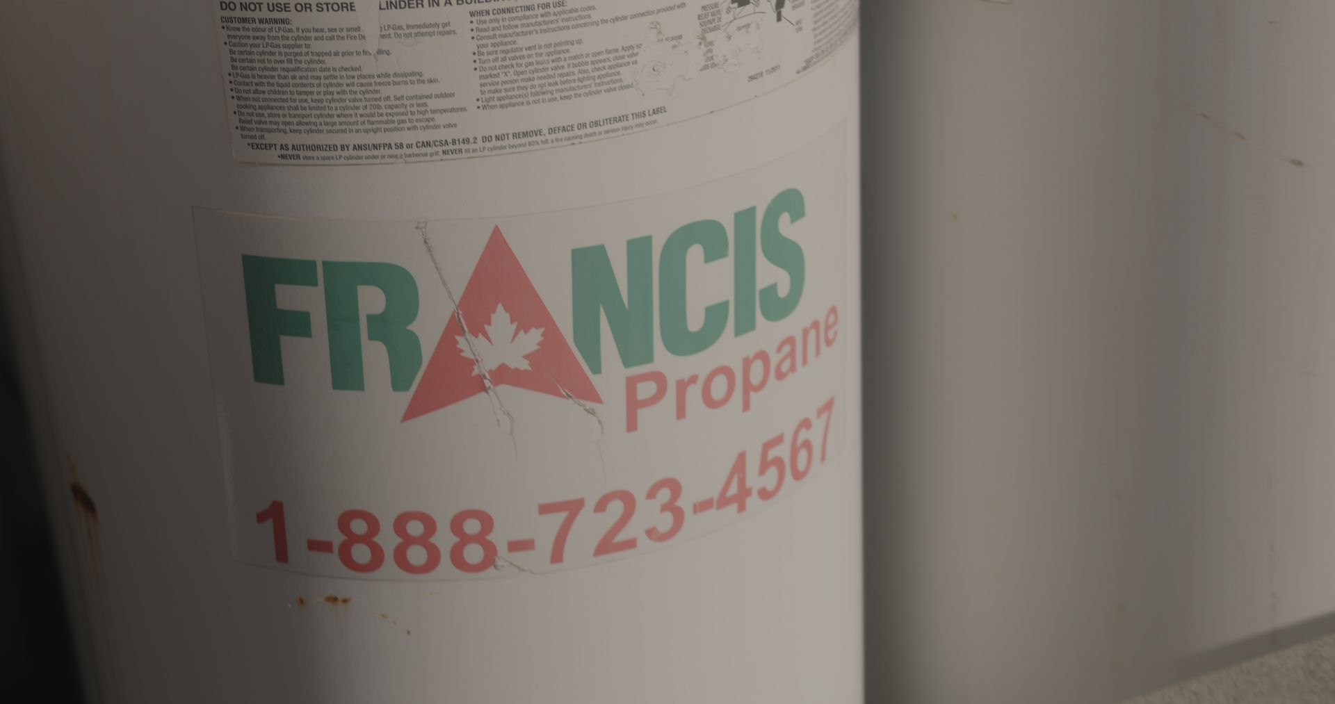 Un gros plan d'un réservoir de propane sur un mur.