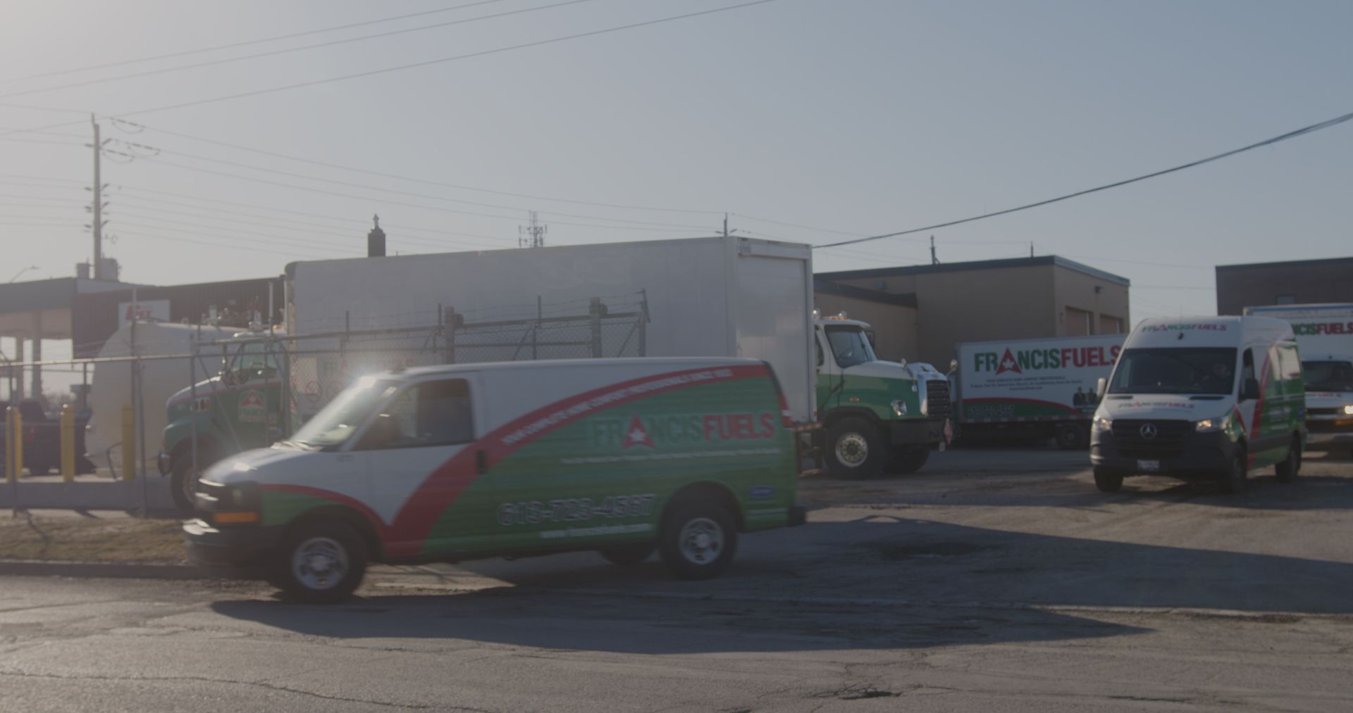 Une camionnette verte et blanche est garée sur un parking.