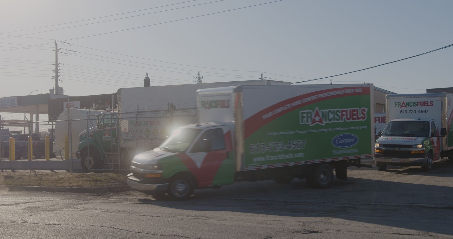 Un camion vert et blanc est garé sur un parking.