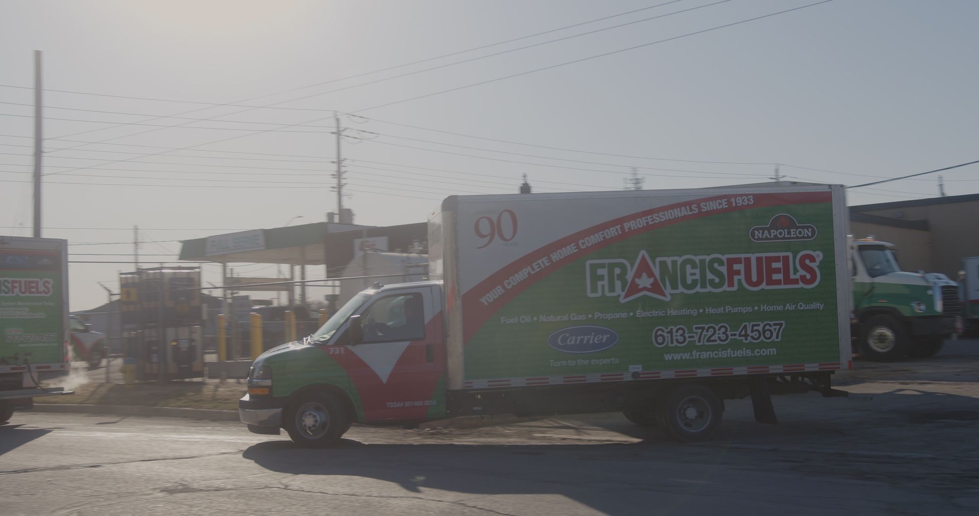 Un camion vert et blanc est garé sur le bord de la route.