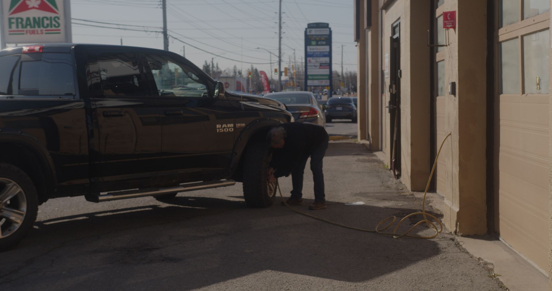 Un homme change un pneu sur un camion devant un restaurant franco's.