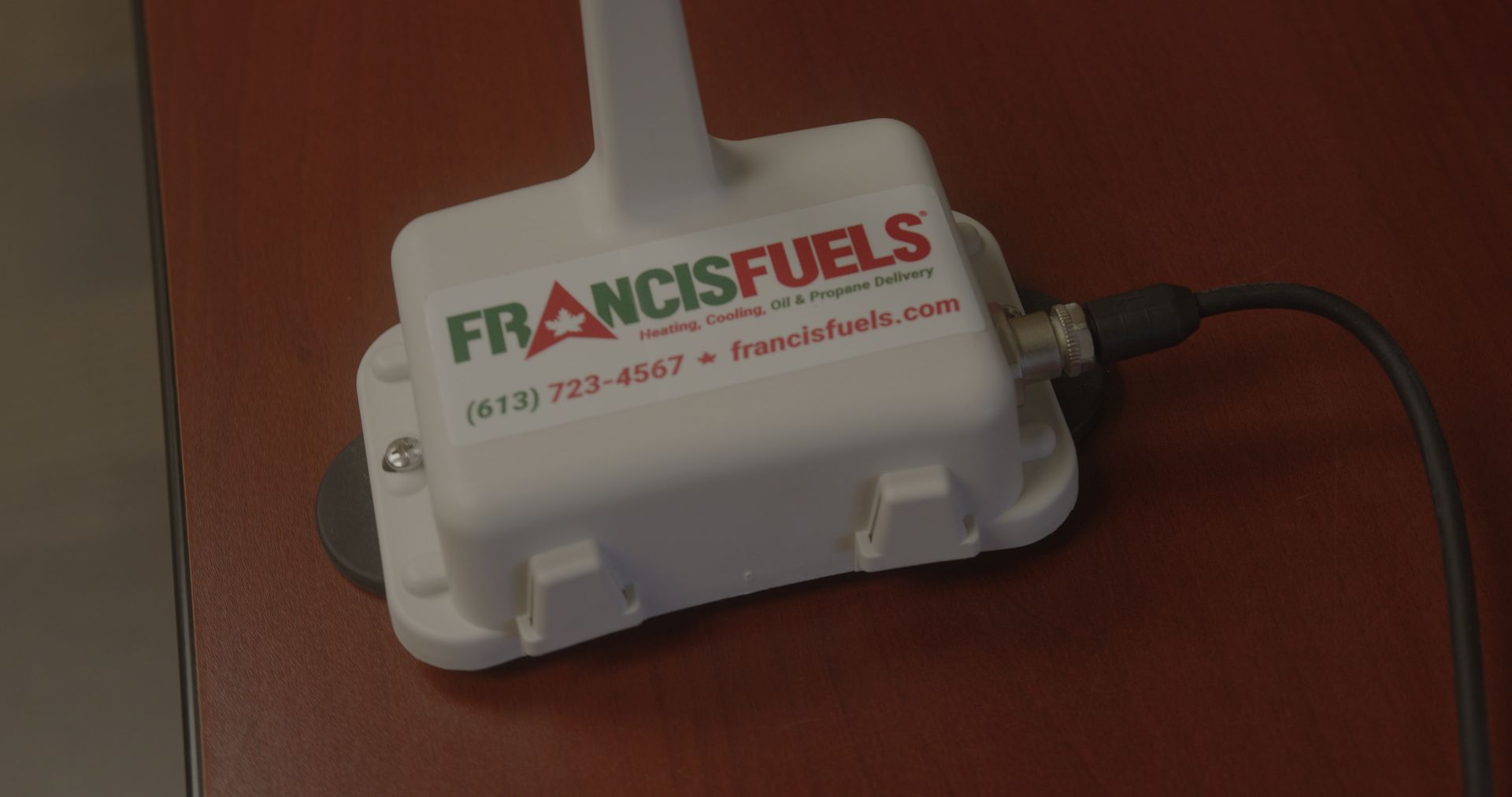 Une boîte blanche avec les mots francisfuels écrits dessus est posée sur une table en bois.