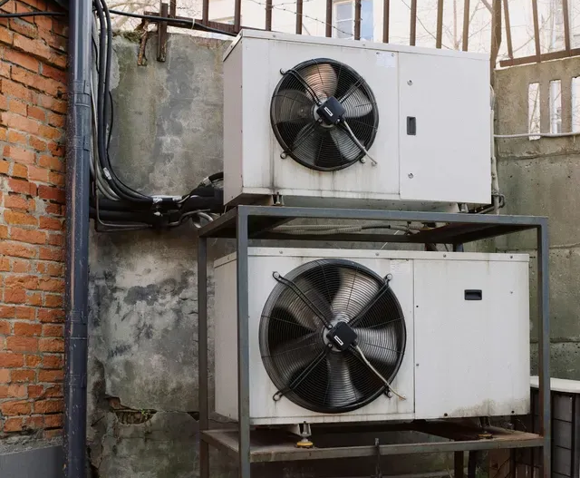 A row of air conditioners on the side of a building