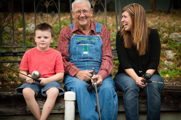 older man fishes with his daughter and grandson