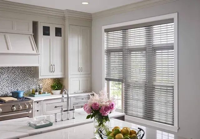 A kitchen with white cabinets , a stove , a sink , and a window with blinds. Love is Blinds Arizona (844) 936-2446