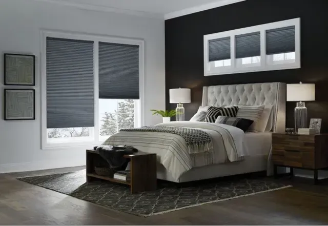 A bedroom with a bed , nightstand , and window shades. Love is Blinds Arizona (844) 936-2446
