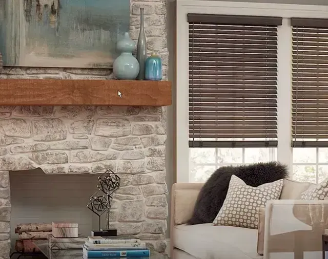 A living room with a fireplace , couch , and wooden blinds. Love is Blinds Arizona (844) 936-2446
