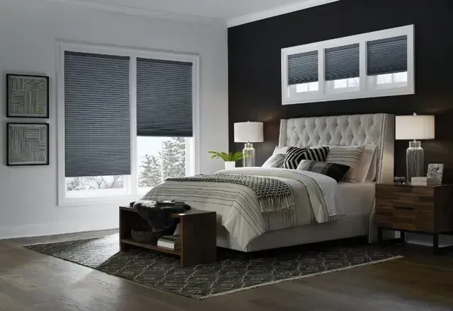 A bedroom with a bed , nightstand , and window shades. Love is Blinds Michigan