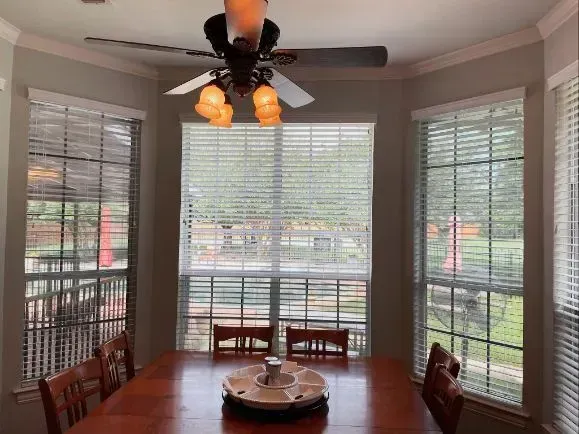 A dining room with a table and chairs and a ceiling fan Love is Blinds Arizona (844) 936-2446