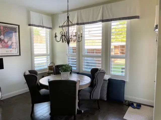 A dining room with a table and chairs and a chandelier. Love is Blinds Michigan