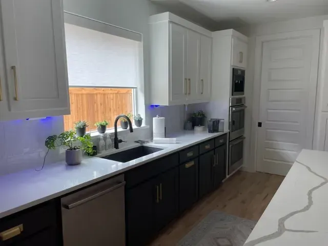 A kitchen with white cabinets , black cabinets , a sink , and a window. Love is Blinds Arizona (844) 936-2446