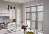 A kitchen with white cabinets , a stove , a sink , and a window with blinds. Love is Blinds Arizona (844) 936-2446